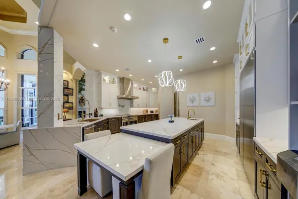 a large kitchen with kitchen island a sink a stove a refrigerator and a dining table with wooden floor
