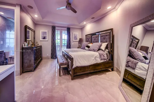 a bedroom with a bed wooden floor and flat screen tv