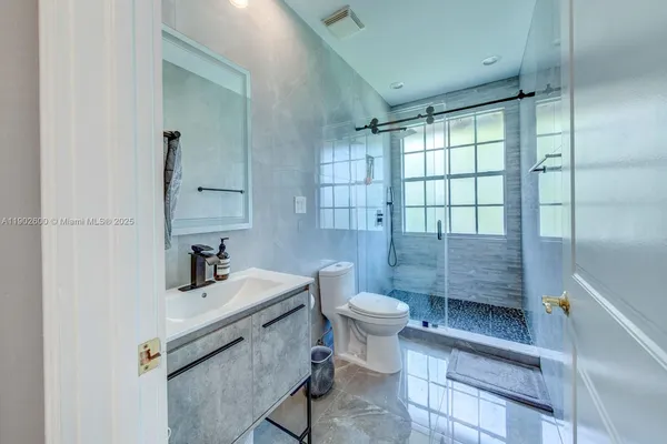 a bathroom with a sink toilet a mirror and shower
