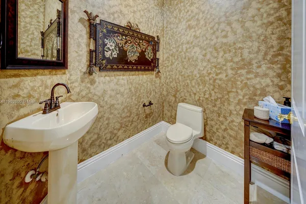 a bathroom with a toilet sink and mirror