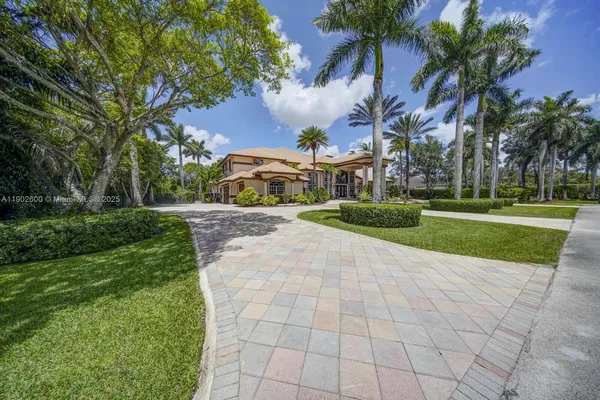 a front view of a house with a yard and trees