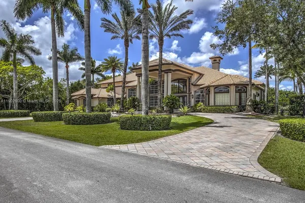 a front view of a house with a yard and potted plants