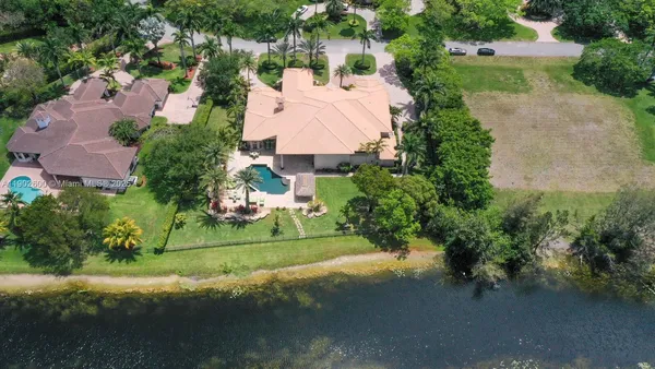 an aerial view of a house with a yard and lake view