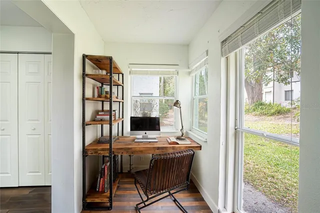 a view of a workspace with furniture and a window