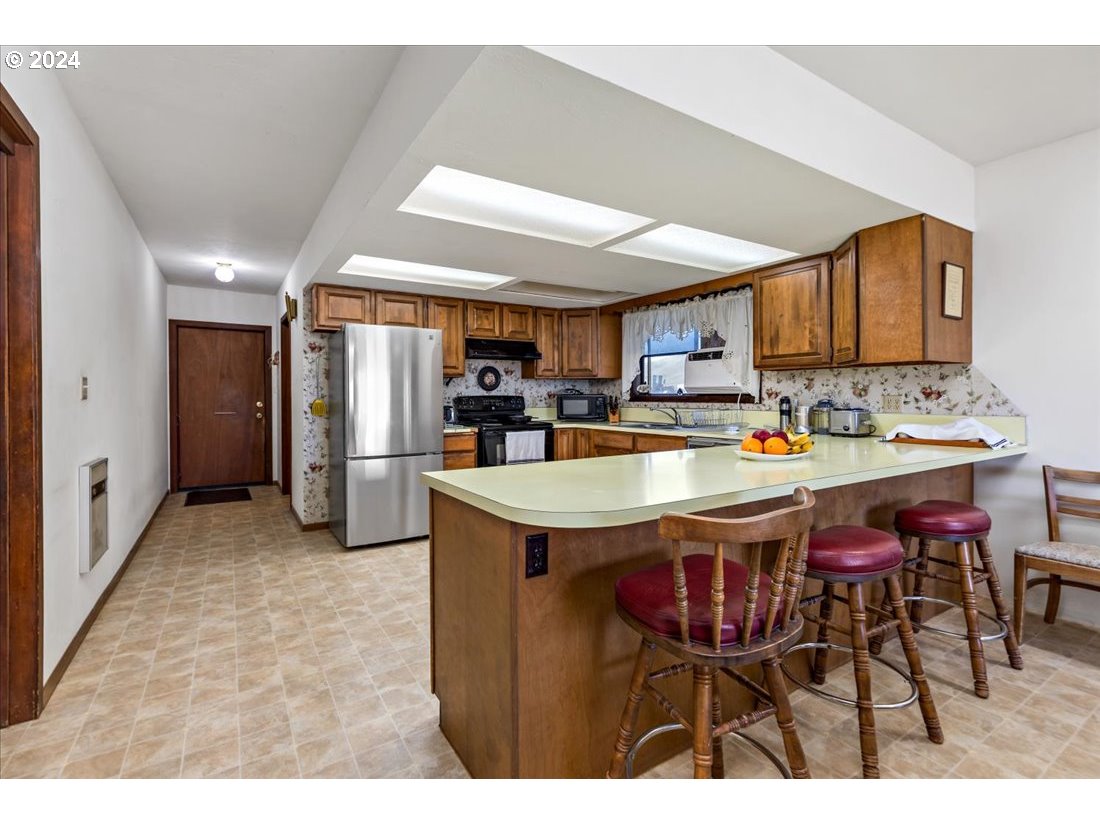 5645 Highway 201 Ontario, OR 97914 - Photo 29 of 32 a dining hall with stainless steel appliances kitchen island granite countertop a table chairs and a refrigerator