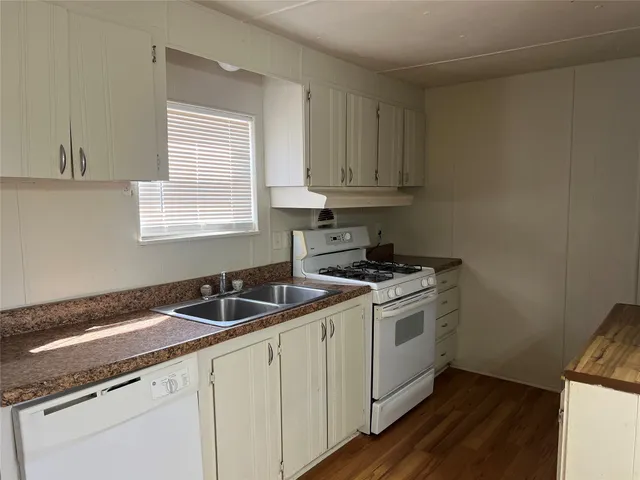 a kitchen with granite countertop a sink and a stove