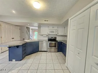 a kitchen with stainless steel appliances granite countertop a stove a sink dishwasher and a refrigerator