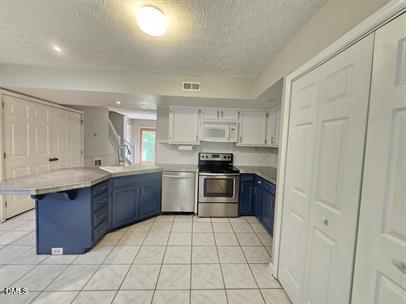 8184 McGuire Drive Raleigh, NC 27616 - Photo 5 of 13 a kitchen with stainless steel appliances granite countertop a stove a sink dishwasher and a refrigerator
