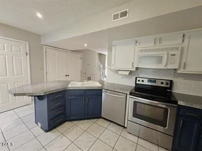 a kitchen with a stove sink and cabinets
