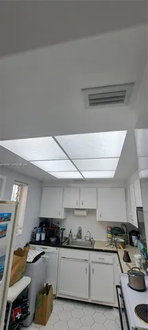 a kitchen with a sink a stove and cabinets