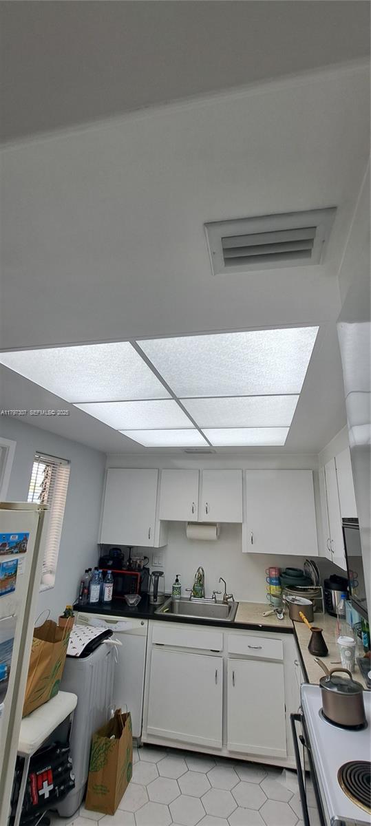 450 Golden Isles Drive, Unit 2H Hallandale Beach, FL 33009 - Photo 11 of 24 a kitchen with a sink a stove and cabinets