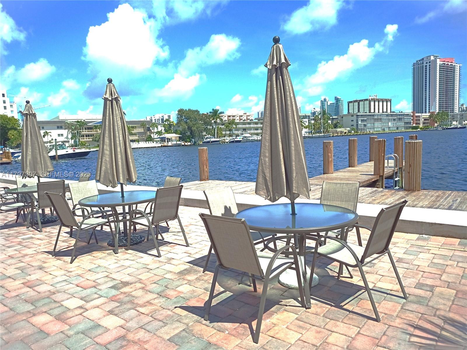 450 Golden Isles Drive, Unit 2H Hallandale Beach, FL 33009 - Photo 12 of 24 a view of a patio with a table and chairs