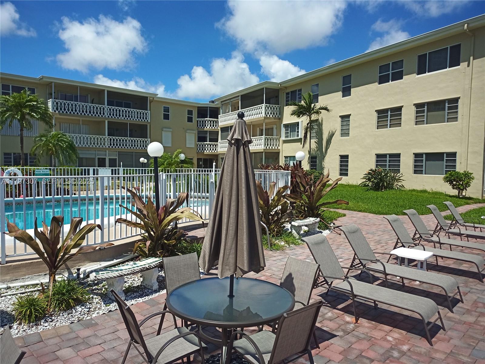 450 Golden Isles Drive, Unit 2H Hallandale Beach, FL 33009 - Photo 20 of 24 a view of a patio with a table and chairs