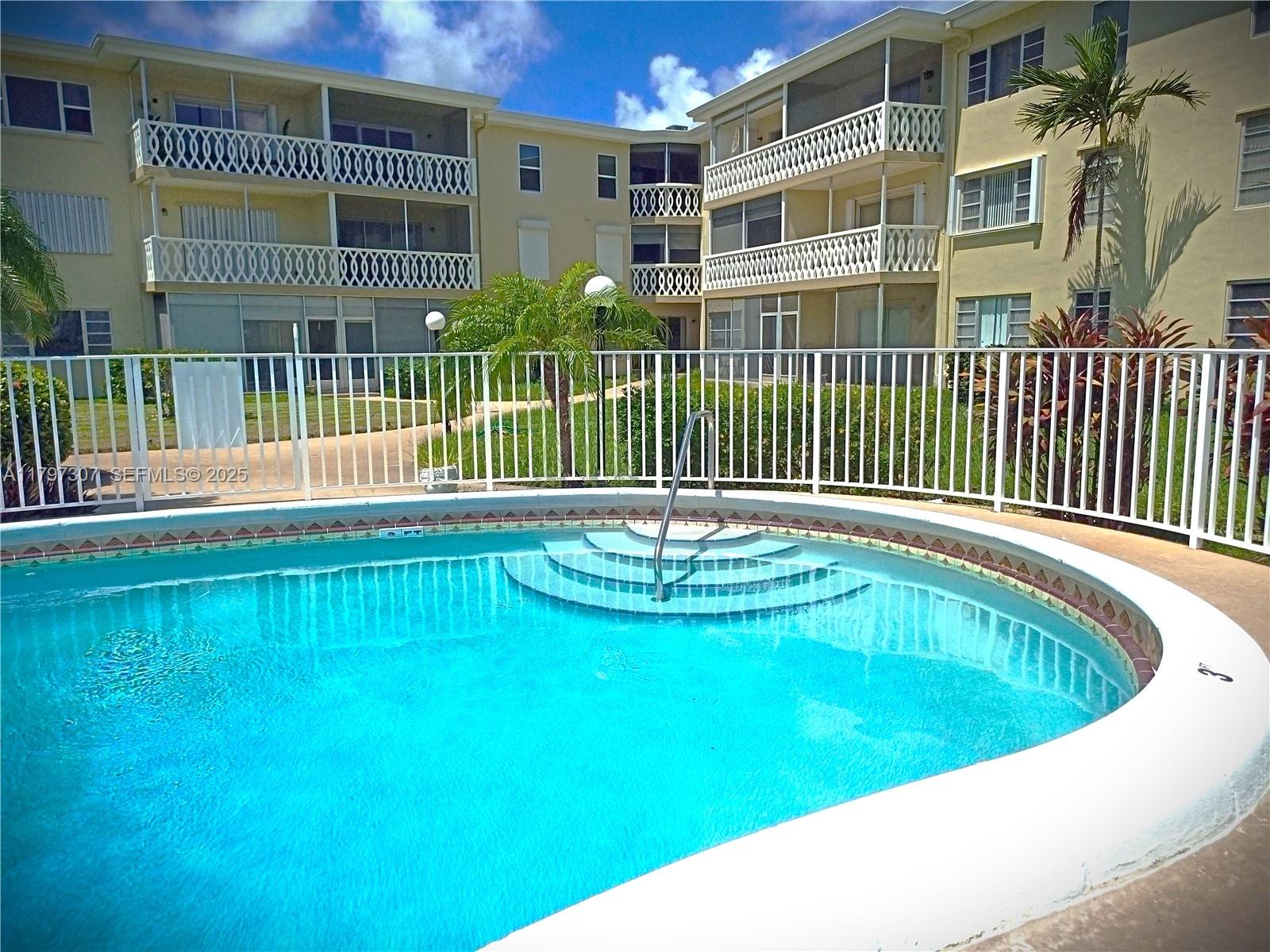 450 Golden Isles Drive, Unit 2H Hallandale Beach, FL 33009 - Photo 23 of 24 a view of pool with a backyard