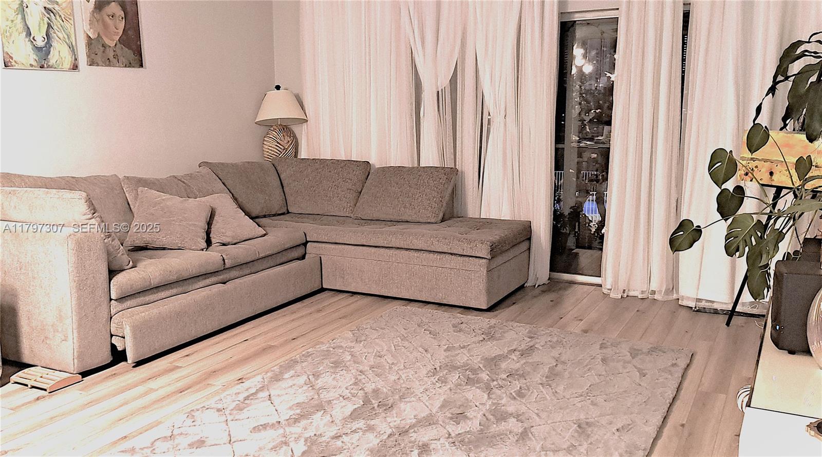 450 Golden Isles Drive, Unit 2H Hallandale Beach, FL 33009 - Photo 6 of 24 a living room with furniture and a flat screen tv