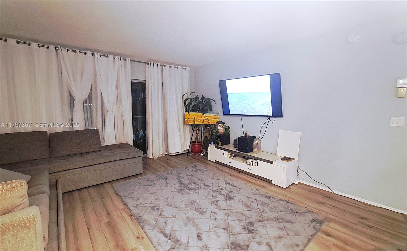 450 Golden Isles Drive, Unit 2H Hallandale Beach, FL 33009 - Photo 7 of 24 a living room with furniture and a wooden floor