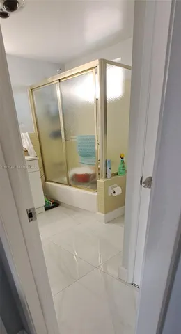 a bathroom with a glass shower door and a sink