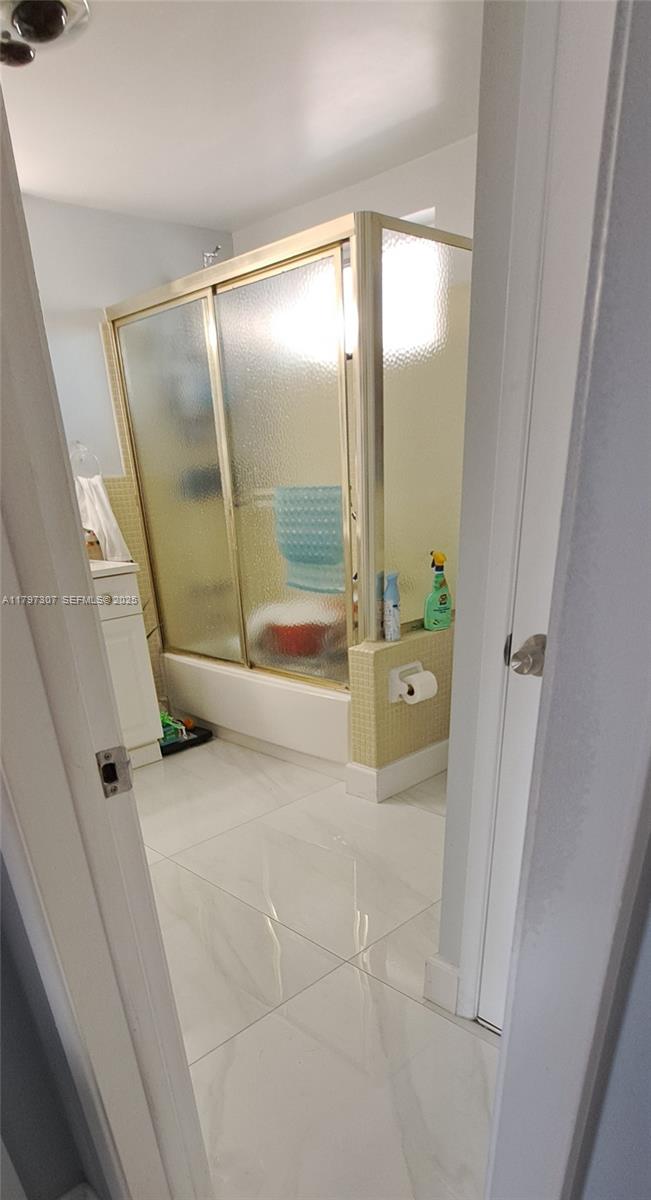 450 Golden Isles Drive, Unit 2H Hallandale Beach, FL 33009 - Photo 9 of 24 a bathroom with a glass shower door and a sink