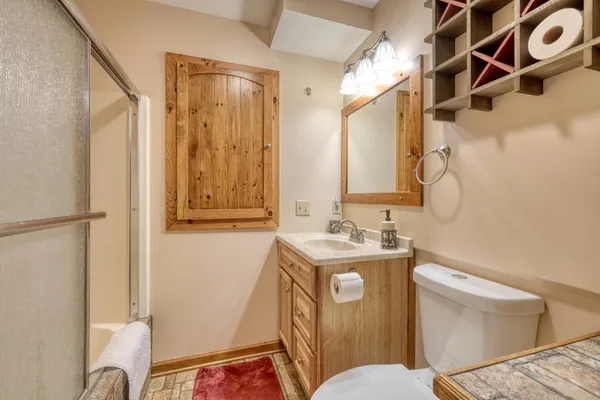 a bathroom with a sink a toilet and shower