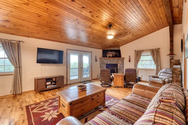 a living room with furniture a flat screen tv and a fireplace