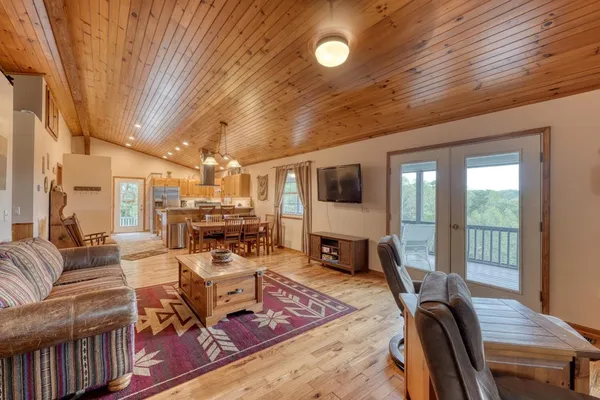 a living room with furniture a flat screen tv and a large window