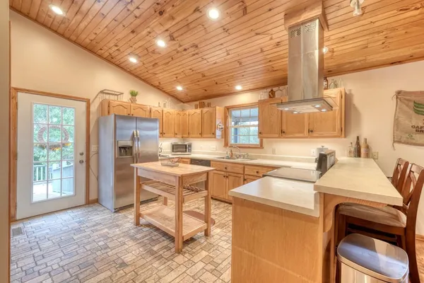 a open kitchen with stainless steel appliances granite countertop a sink a stove a refrigerator cabinets and chairs