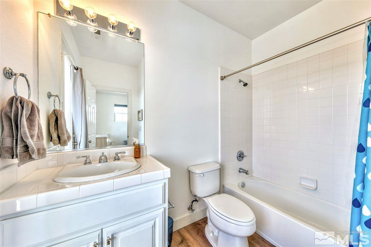 2931 Flint Ridge Court Reno, NV 89511 - Photo 32 of 37 a bathroom with a sink a toilet a mirror and shower