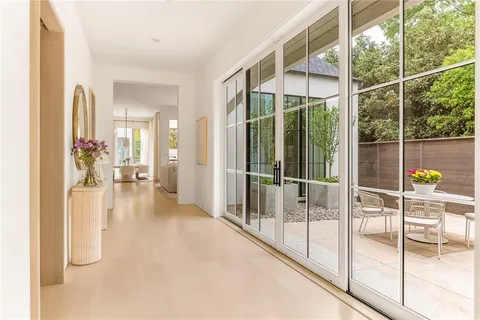 a view of a patio with table and chairs potted plants and floor to ceiling window and potted plants