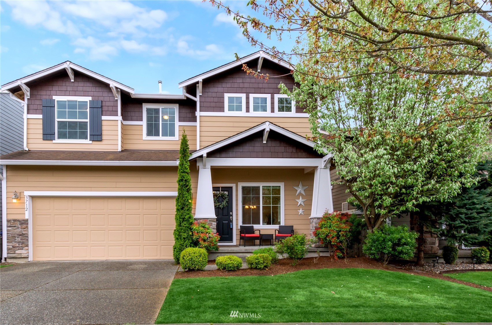 3712 224th Street Southeast Bothell, WA 98021 - Photo 1 of 24 a view of a yard in front of a house with plants and large tree