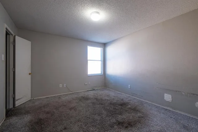 an empty room with a window and closet