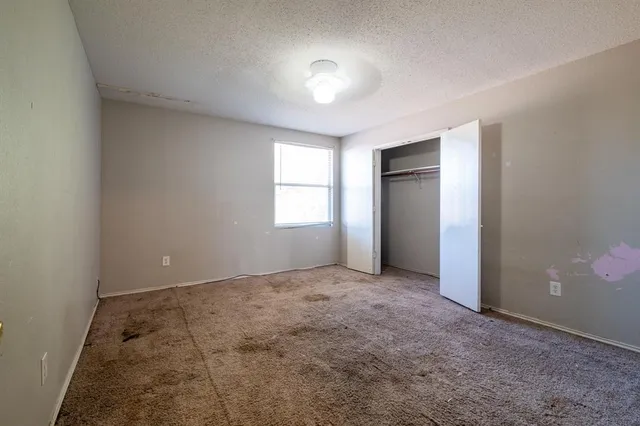 an empty room with windows and closet