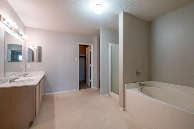 a bathroom with a tub sink and mirror