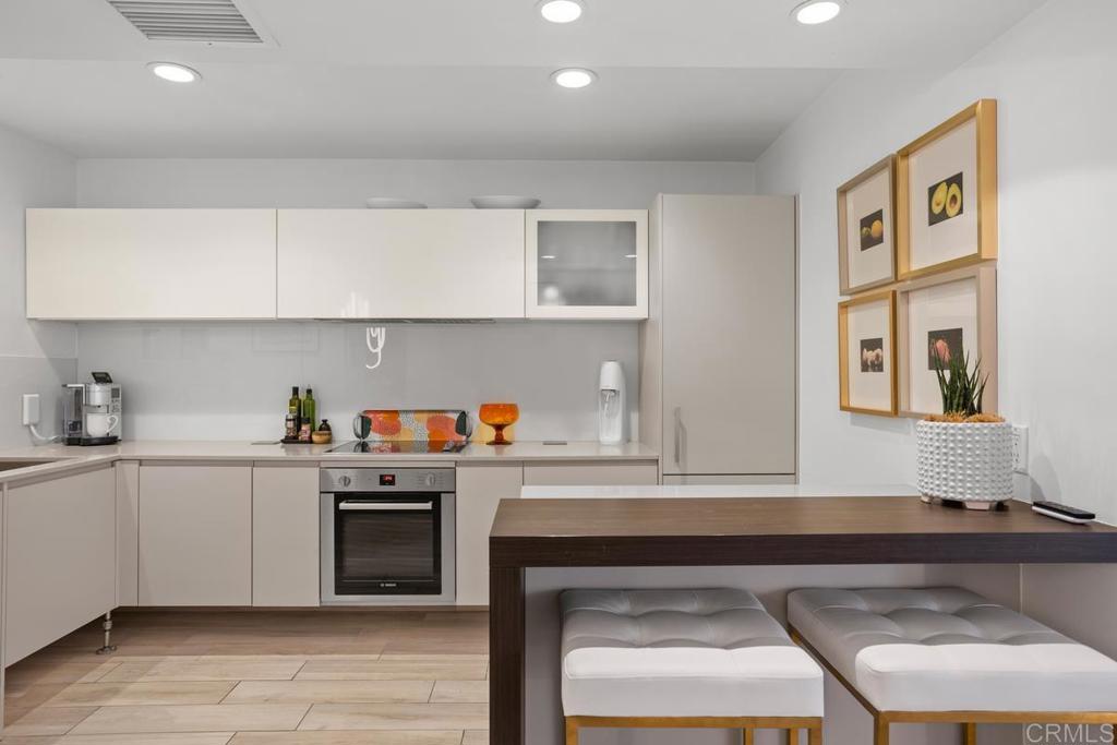 940 Sealane Drive, Unit 3 Encinitas, CA 92024 - Photo 11 of 29 a kitchen with stainless steel appliances granite countertop a stove a sink and white cabinets