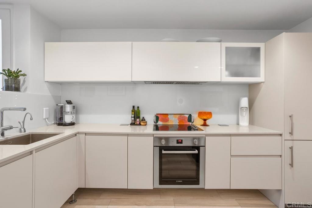 940 Sealane Drive, Unit 3 Encinitas, CA 92024 - Photo 12 of 29 a kitchen with white cabinets and sink