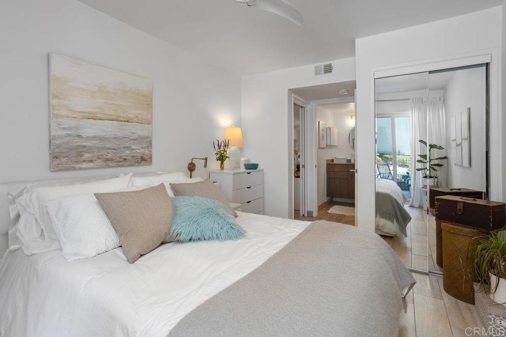 940 Sealane Drive, Unit 3 Encinitas, CA 92024 - Photo 19 of 29 a bedroom with a large bed and a chandelier
