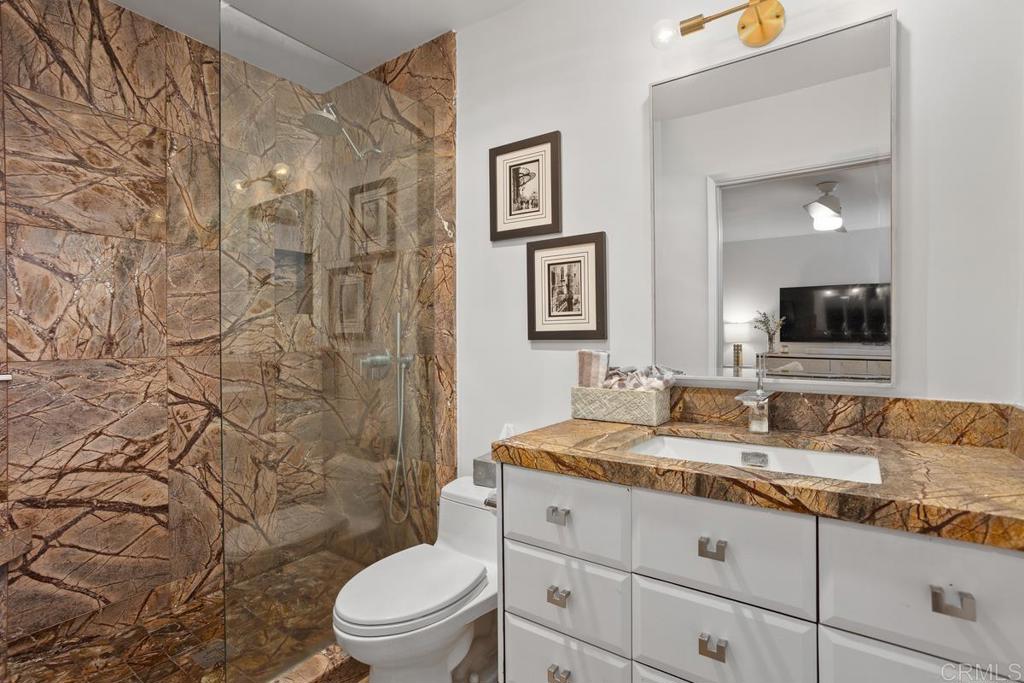 940 Sealane Drive, Unit 3 Encinitas, CA 92024 - Photo 23 of 29 a bathroom with a granite countertop toilet a sink and a mirror
