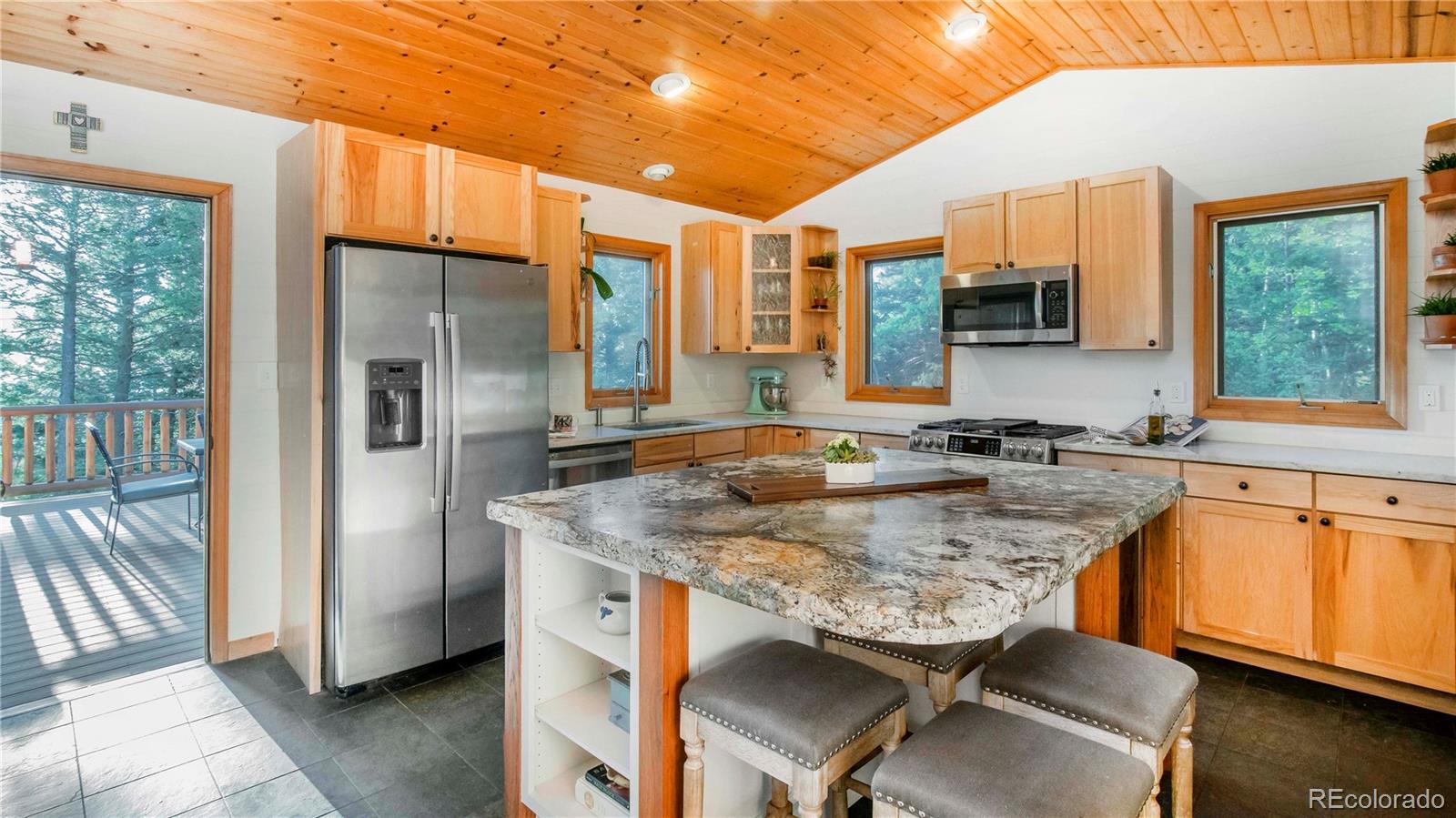 13416 Kuehster Road Littleton, CO 80127 - Photo 17 of 50 a kitchen with stainless steel appliances granite countertop a sink a stove and chairs