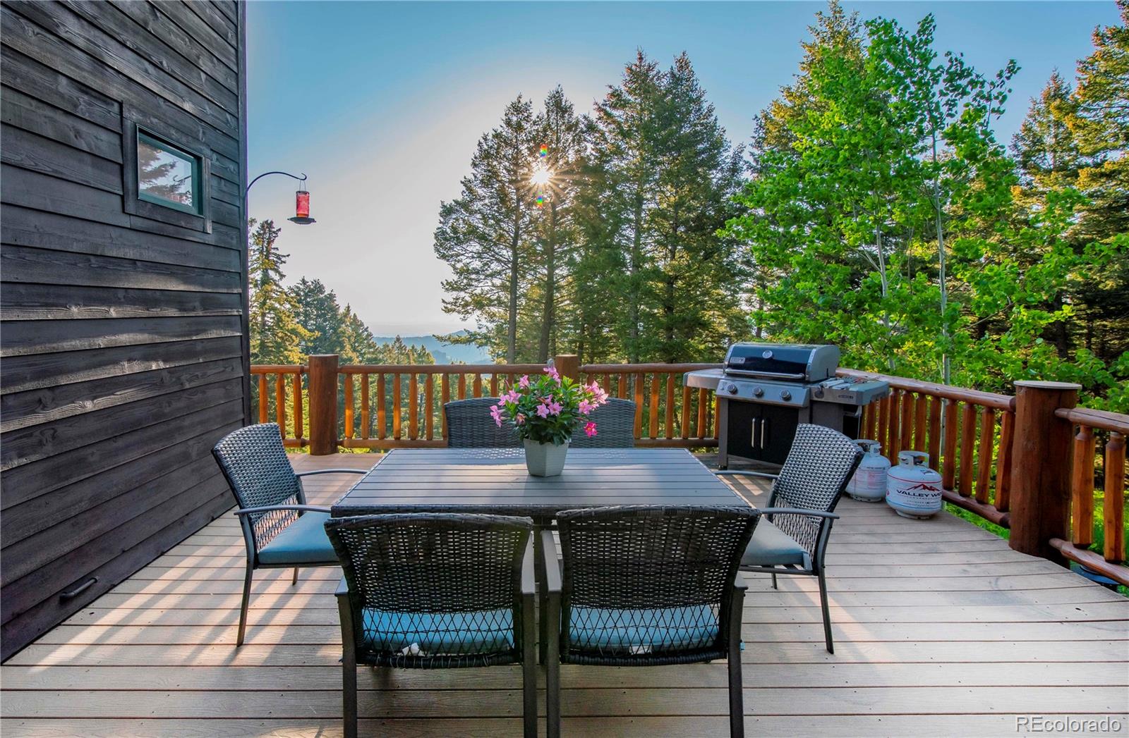13416 Kuehster Road Littleton, CO 80127 - Photo 19 of 50 a view of a roof deck with table and chairs with wooden floor and fence