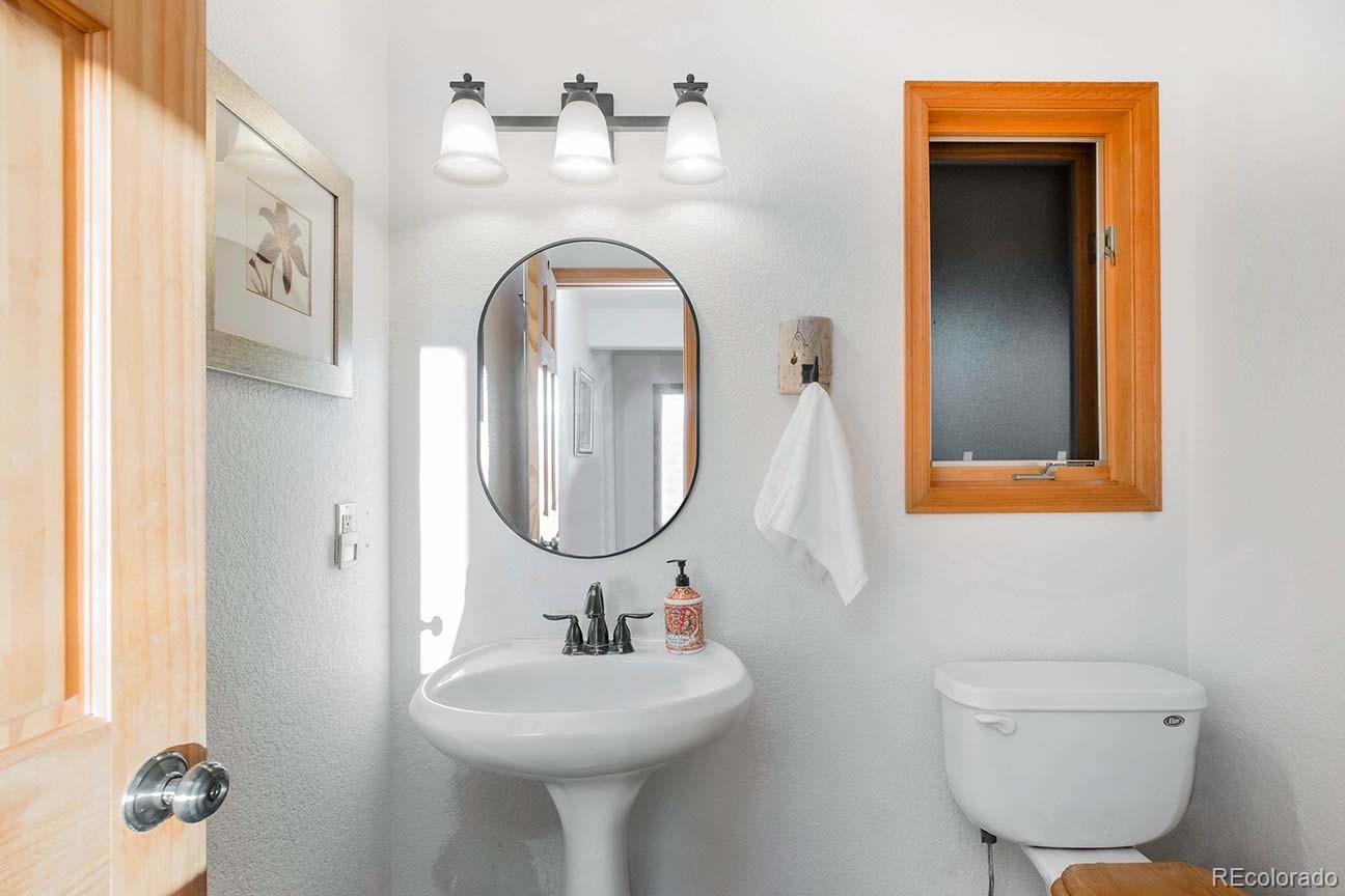 13416 Kuehster Road Littleton, CO 80127 - Photo 27 of 50 a bathroom with a toilet sink and mirror