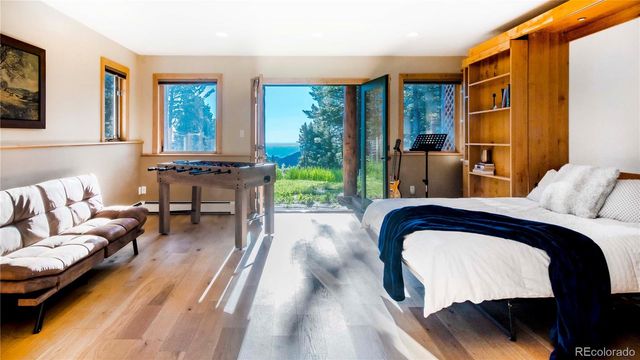 a bedroom with a bed couch and a large window