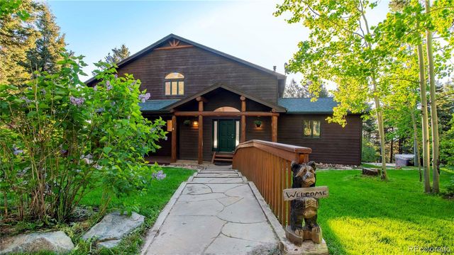 a front view of a house with a yard and trees