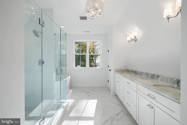 a spacious bathroom with a granite countertop sink a mirror and a bathtub