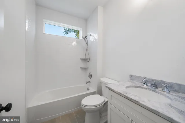 a bathroom with a granite countertop toilet a sink and a bathtub