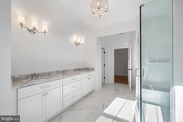 a spacious bathroom with a granite countertop sink a mirror and a shower