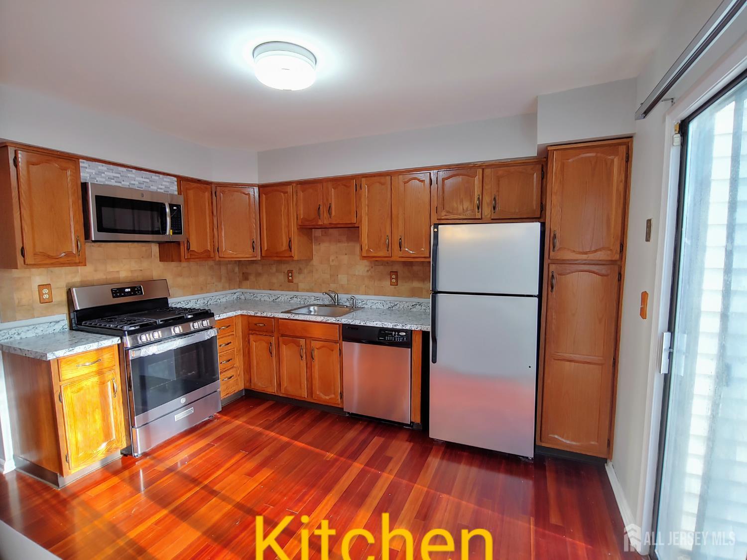 3305 Stonehedge Road Edison, NJ 08820 - Photo 3 of 16 a kitchen with granite countertop wooden floors a stove a sink and a refrigerator