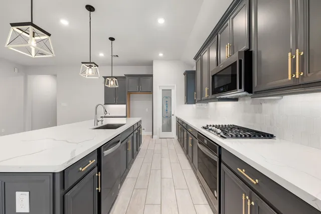 a kitchen with stainless steel appliances a sink stove and cabinets
