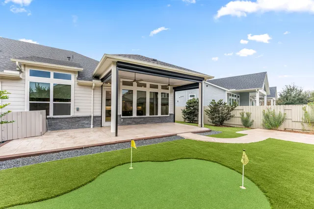 a view of an house with backyard and porch