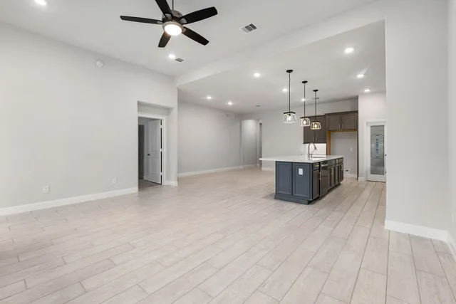 a open kitchen with a sink dishwasher a stove and a refrigerator with wooden floor