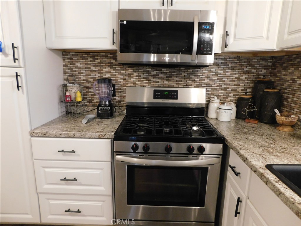 10350 Baseline, Unit 55 Alta Loma, CA 91701 - Photo 20 of 53 a kitchen with stainless steel appliances granite countertop a stove microwave and oven