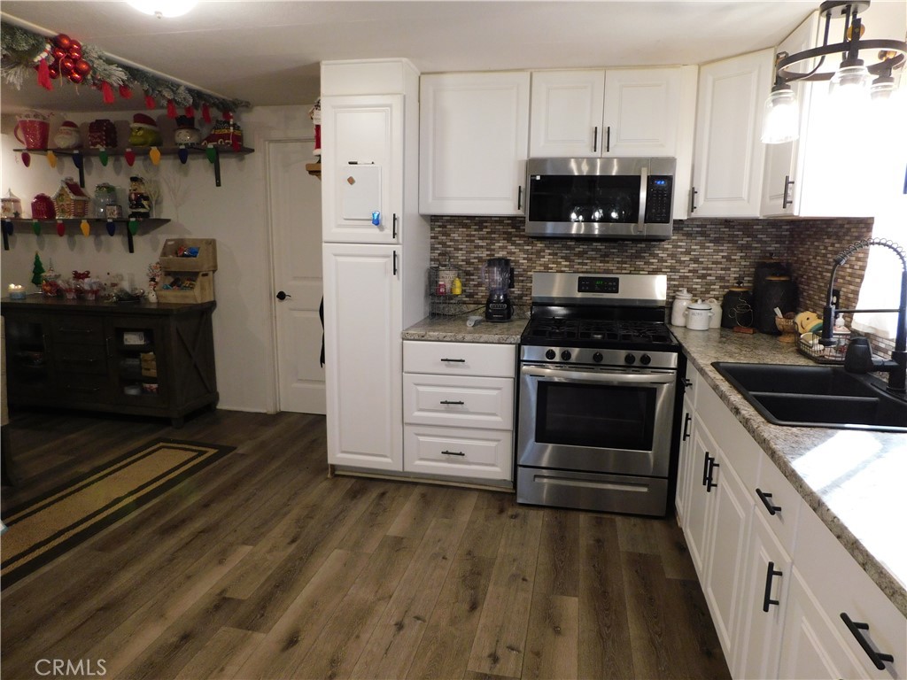 10350 Baseline, Unit 55 Alta Loma, CA 91701 - Photo 23 of 53 a kitchen with stainless steel appliances a stove a microwave and cabinets